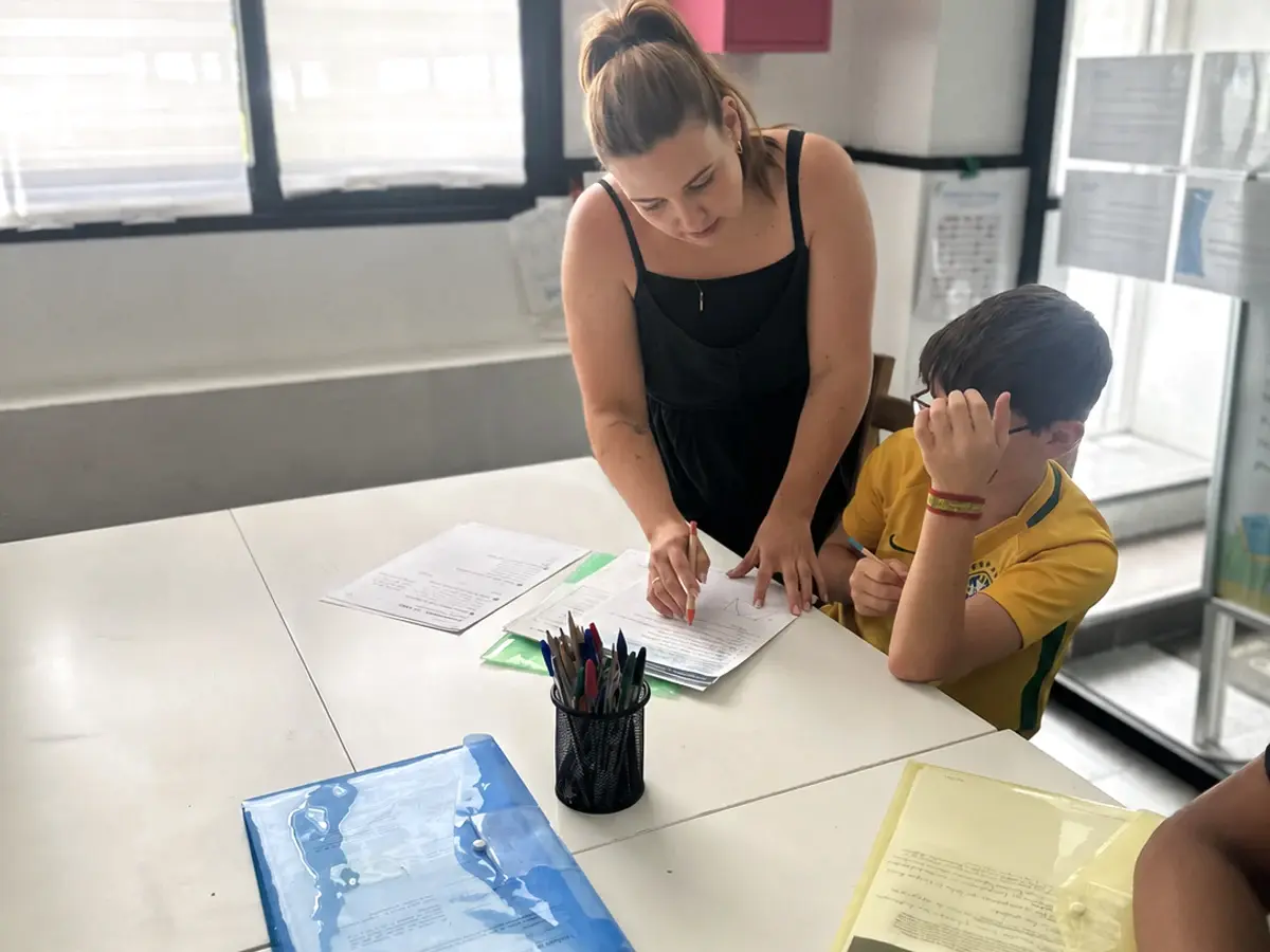 Profesional de Cogiendo Impulso ayudando a un alumno durante una clase